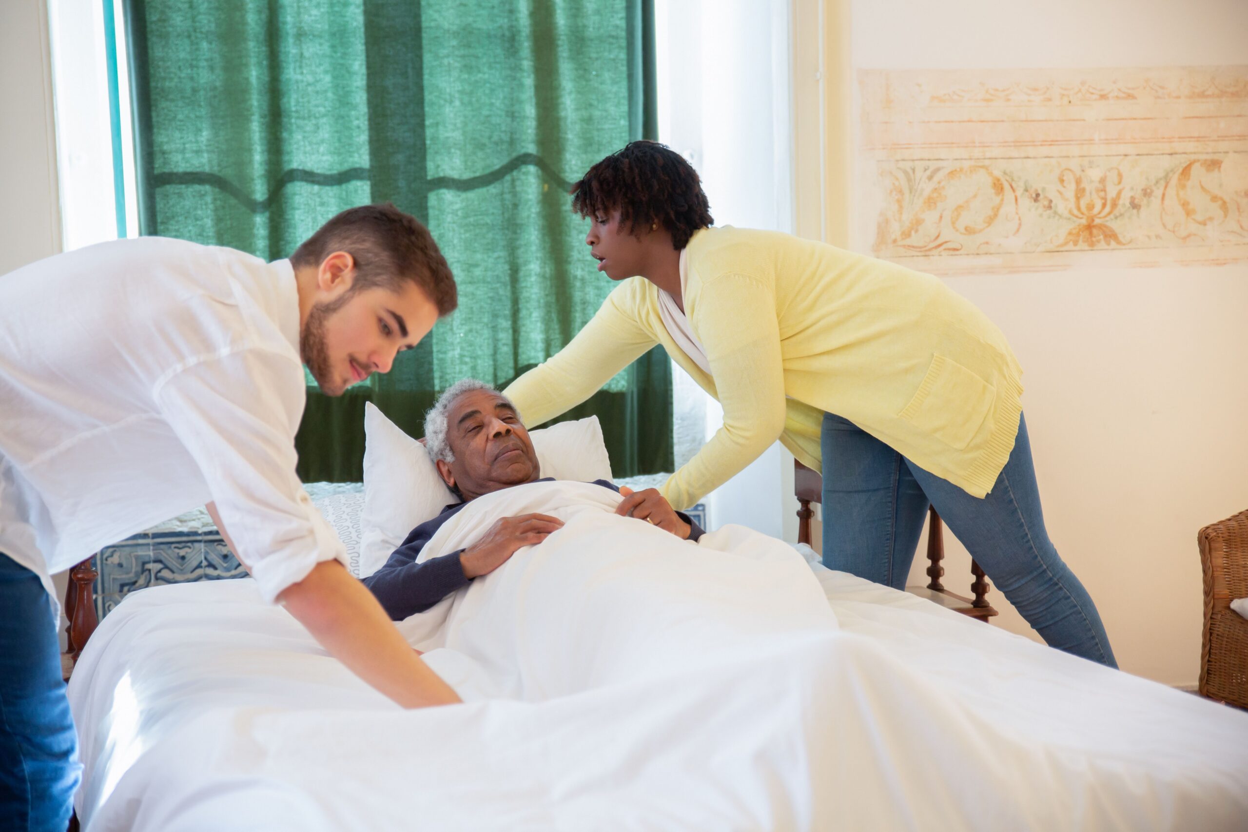 Home healthcare aide assisting senior woman in bed