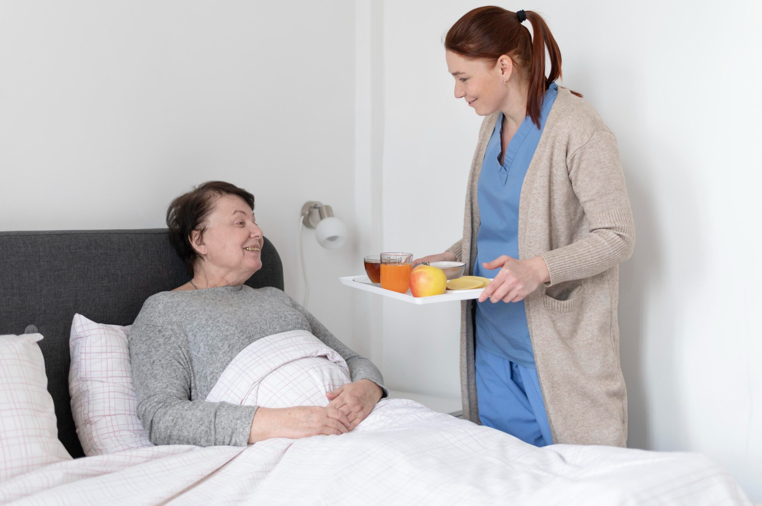 Nurse serving meal to elderly patient